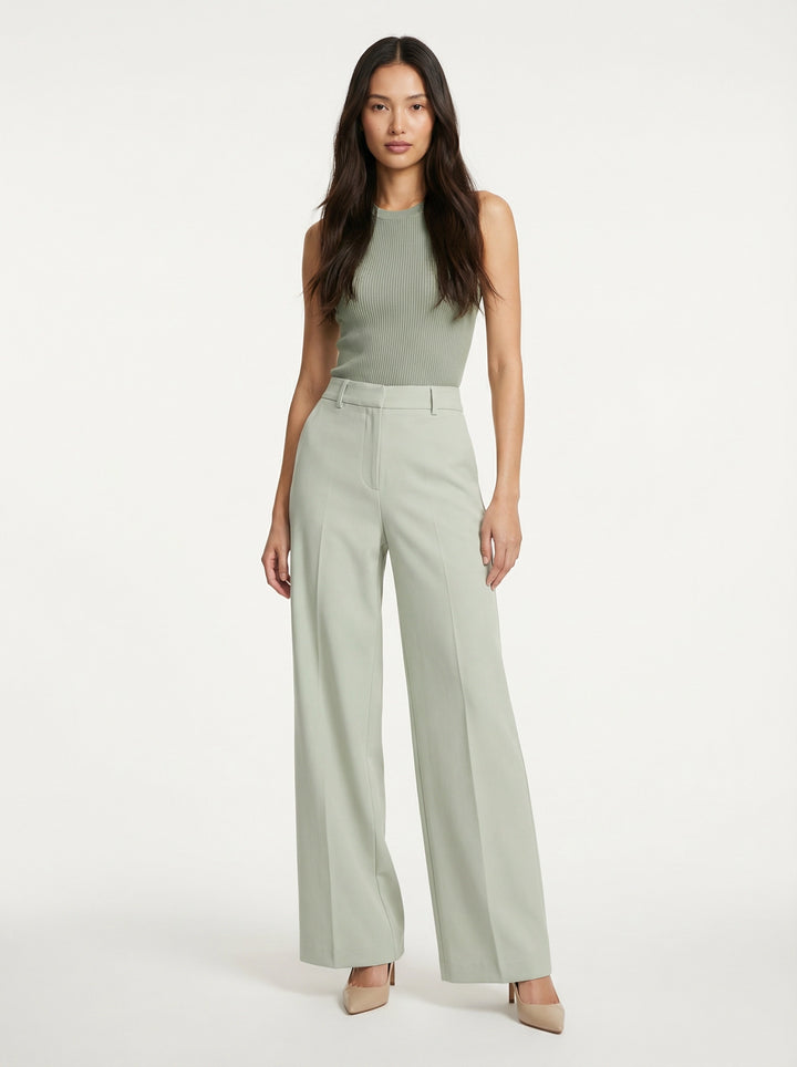 Model wearing SELVANE sage green ribbed knit tank and high-waisted wide-leg trousers set, standing elegantly.