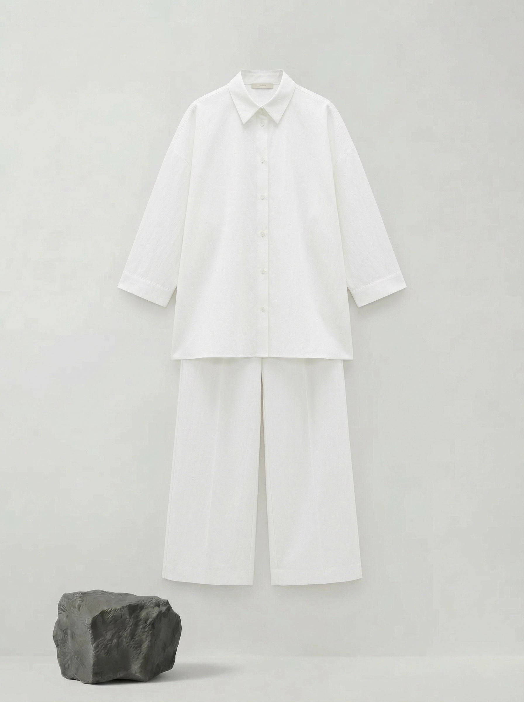 SELVANE pure white bow-tie blouse and wide-leg trousers set in luminous, crinkled acetate fabric, styled elegantly.