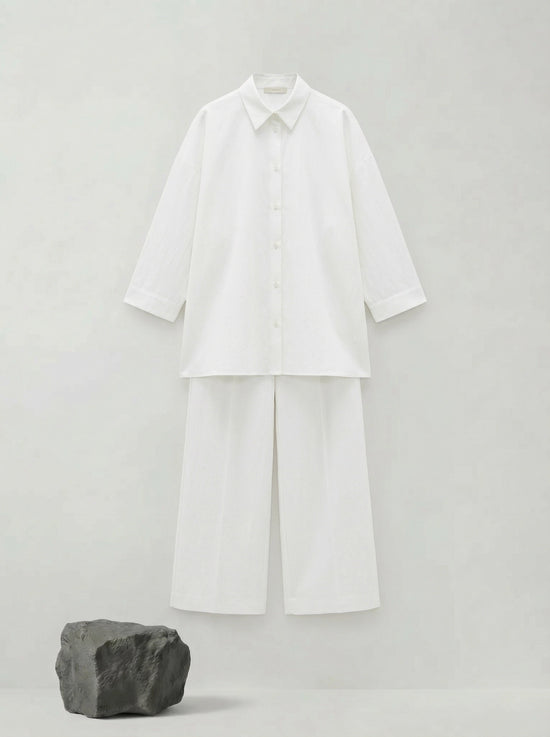 SELVANE pure white bow-tie blouse and wide-leg trousers set in luminous, crinkled acetate fabric, styled elegantly.