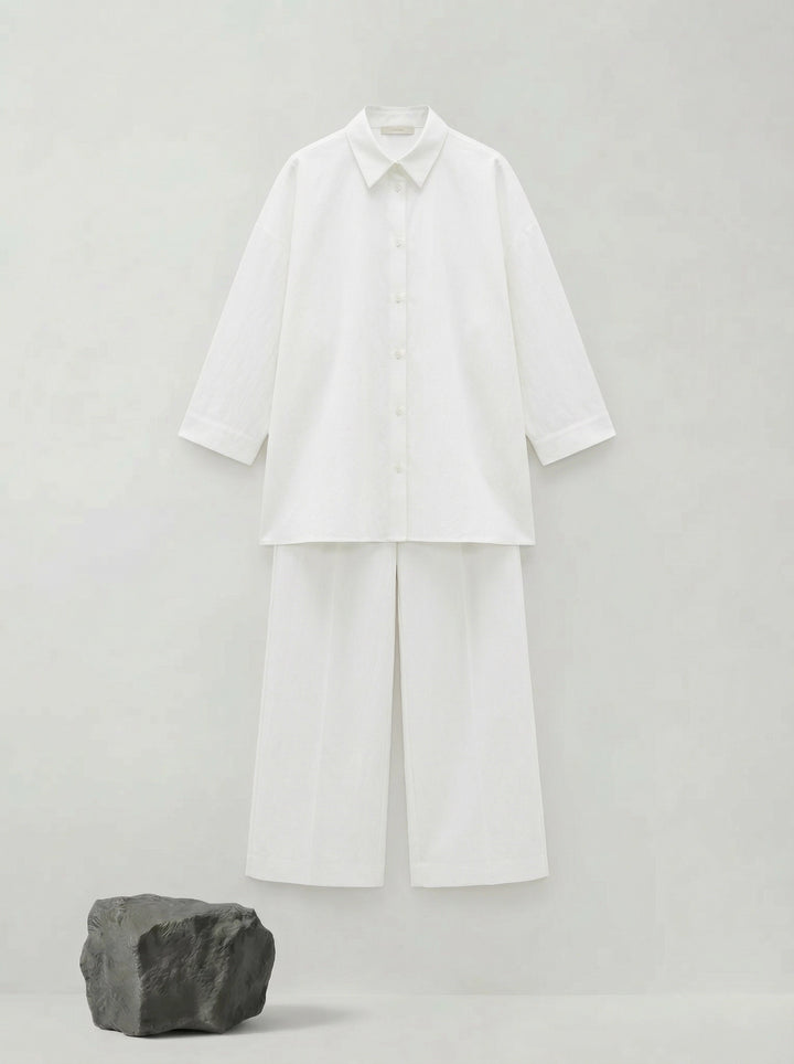 SELVANE pure white bow-tie blouse and wide-leg trousers set in luminous, crinkled acetate fabric, styled elegantly.