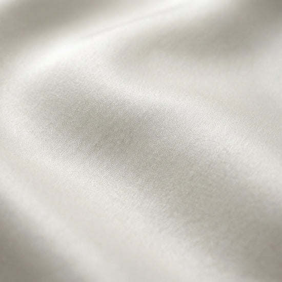 SELVANE pure white bow-tie blouse and wide-leg trousers set in luminous, crinkled acetate fabric, styled elegantly.