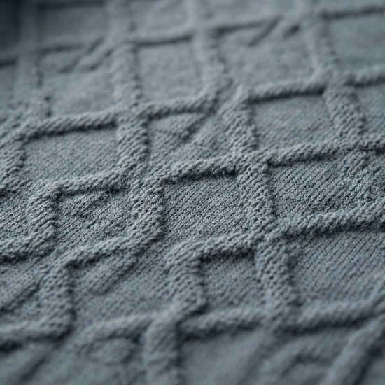 Sleeveless SELVANE Jacquard Knit Tank in muted grey-blue, featuring intricate diamond pattern, horizontal stripes, scoop neckline, and ribbed hem.