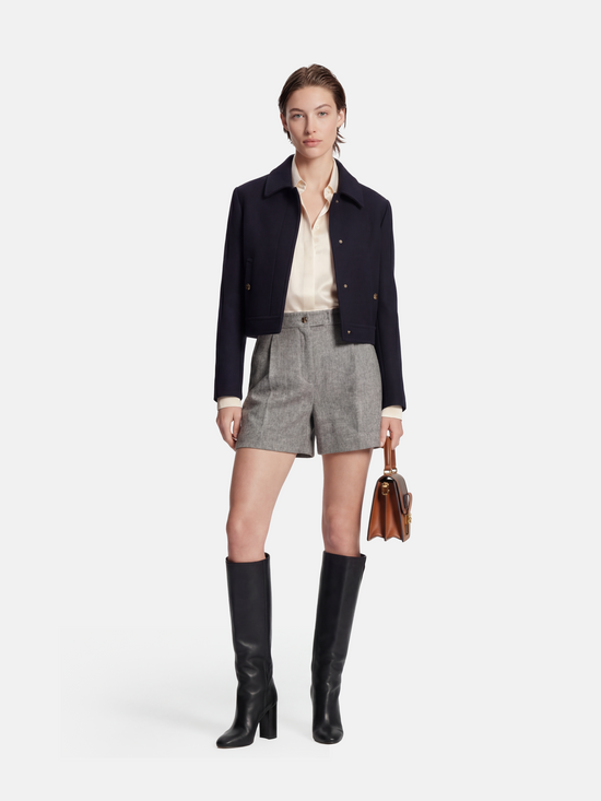 High-waisted grey mélange tailored shorts with front pleats, slightly flared leg, and subtle contrast pocket trims.