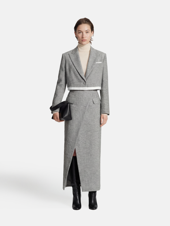 Cropped blazer and wrap midi skirt set in grey, featuring disciplined shoulders and fluid lines, inspired by volcanic terrain.