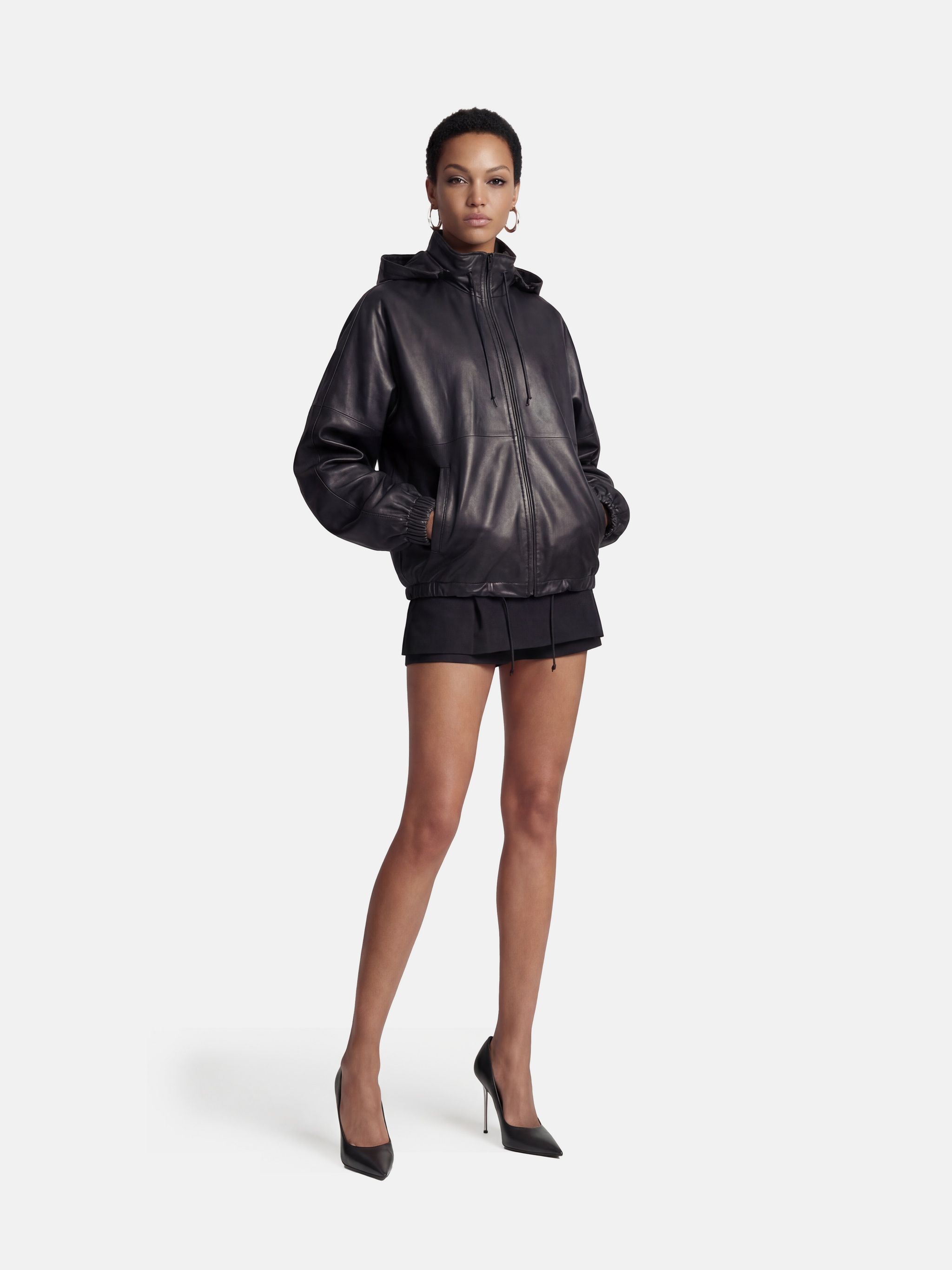 Deep black hooded lambskin zip jacket by SELVANE, featuring a soft utilitarian line and protective design for urban movement.