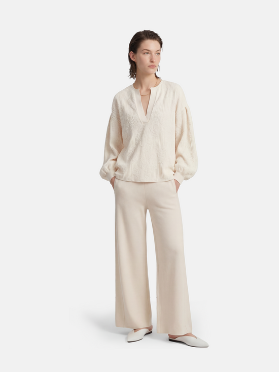 Ivory cashmere wide-leg pants by SELVANE, featuring a soft V-shaped rib waistband and elegant vertical drape.