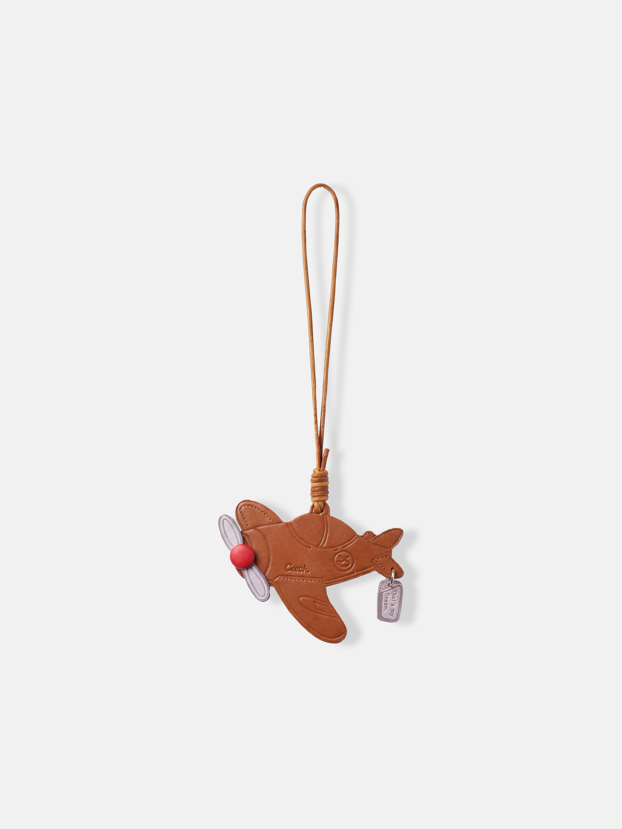 Polished metal Selvane Dream Plane Bag Charm, featuring a sleek aircraft silhouette and 'That's my dream' tag, symbolizing personal journeys.