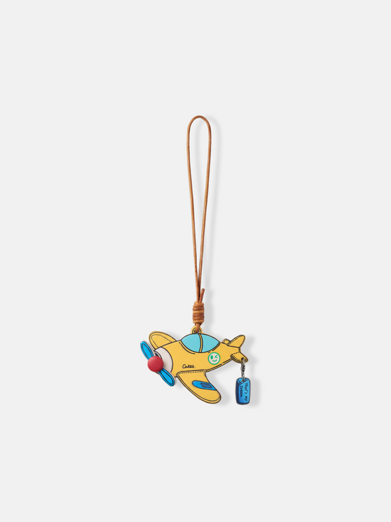 Polished metal Selvane Dream Plane Bag Charm, featuring a sleek aircraft silhouette and 'That's my dream' tag, symbolizing personal journeys.