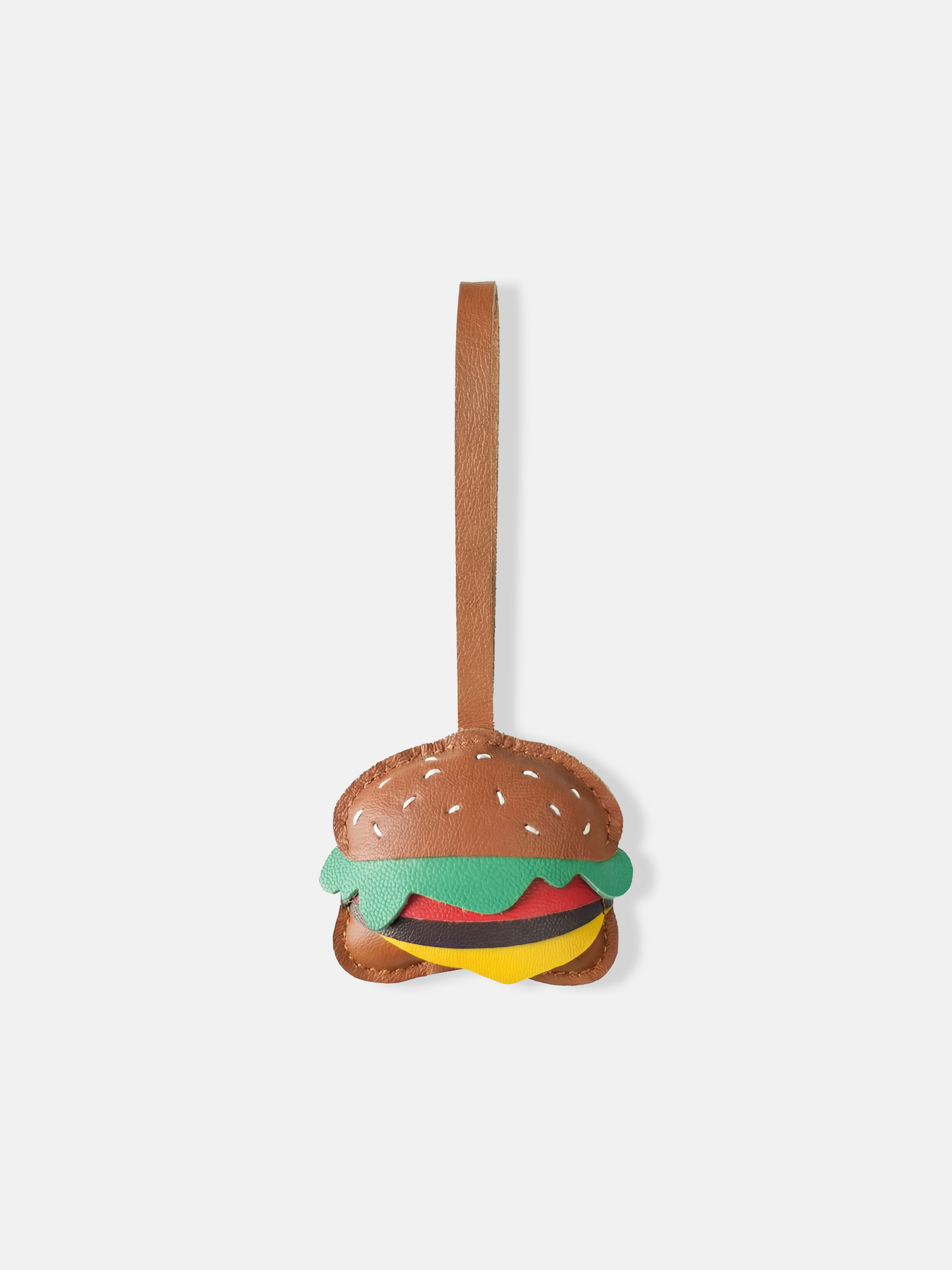 Selvane Hamburger Bag Charm, a compact, graphic burger silhouette crafted from smooth pebbled-leather with a long strap.