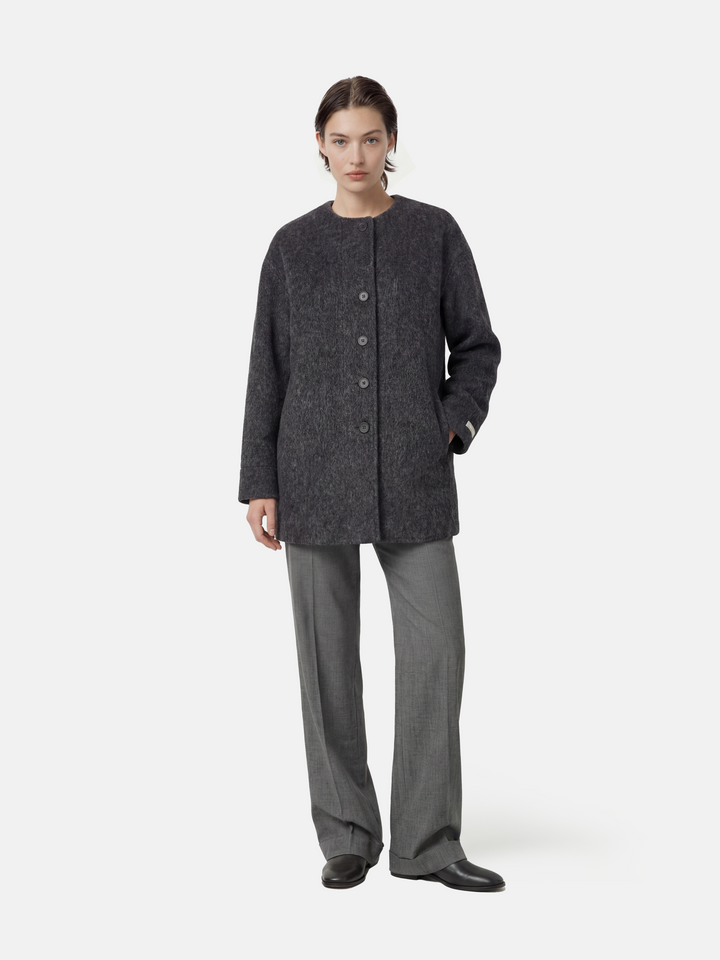 Beige wool and camel hair buttoned coat by SELVANE, featuring a rounded neck and minimal buttons, draped elegantly.