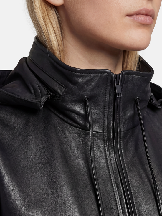 Deep black hooded lambskin zip jacket by SELVANE, featuring a soft utilitarian line and protective design for urban movement.