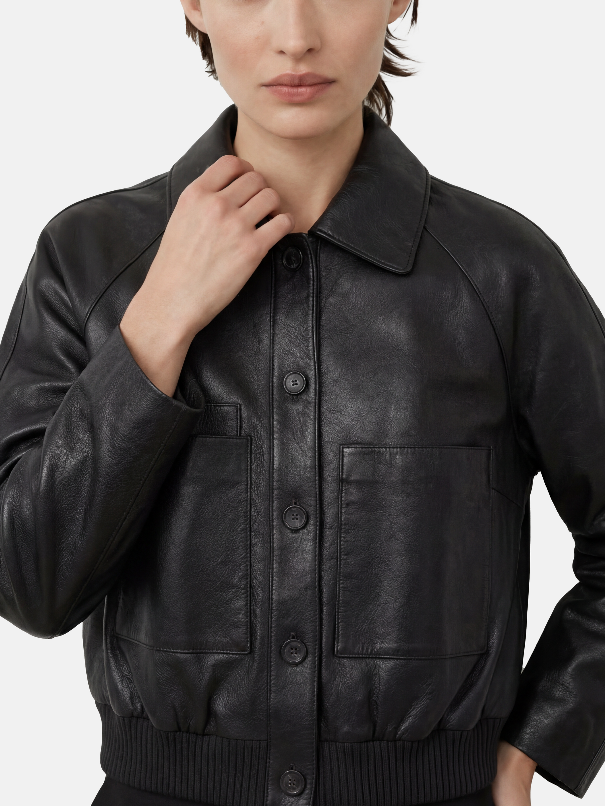 SELVANE deep black lambskin button bomber, cropped silhouette with ribbed hem and oversized patch pockets.